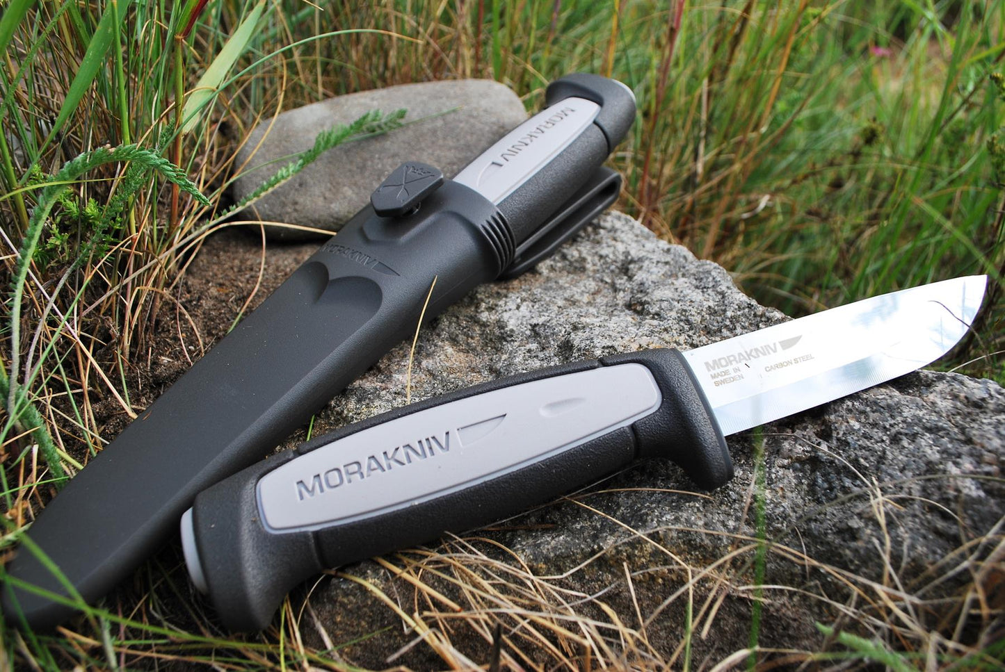 MORAKNIV Robust Gray fiksuotas peilis iš anglies plieno su tvirtu dėklu ir ergonomine rankena gamtoje ant akmens.
