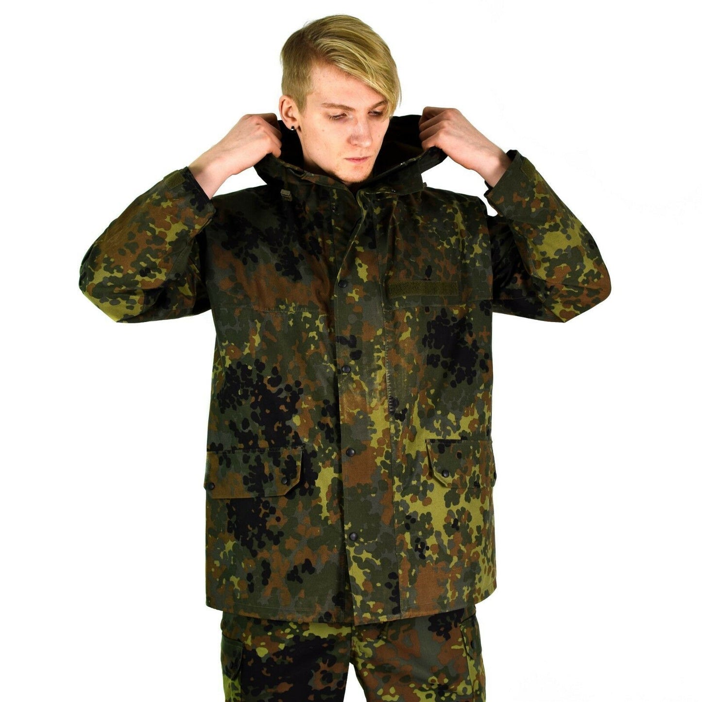 Vyras užsideda gobtuvą dėvėdamas Vokietijos kariuomenės neperšlampamą GoreTex striukę Flecktarn marginimo.