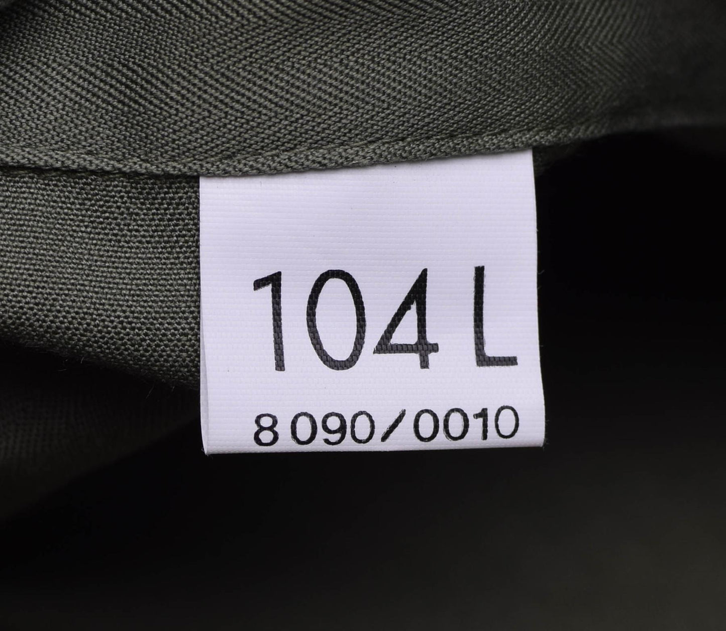 Prancūzijos kariuomenės F2 uniforminis švarkas alyvuogių spalvos etiketė su dydžiu 104 L ir gaminio kodu.