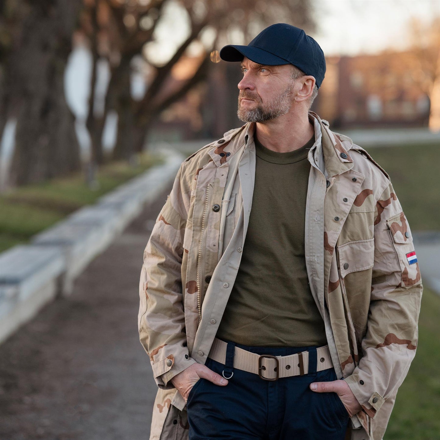 Čekijos kariuomenės taktinis diržas Chaki, demonstruojamas su kariška striuke ir kepure, ryškiai matoma metalinė sagtis