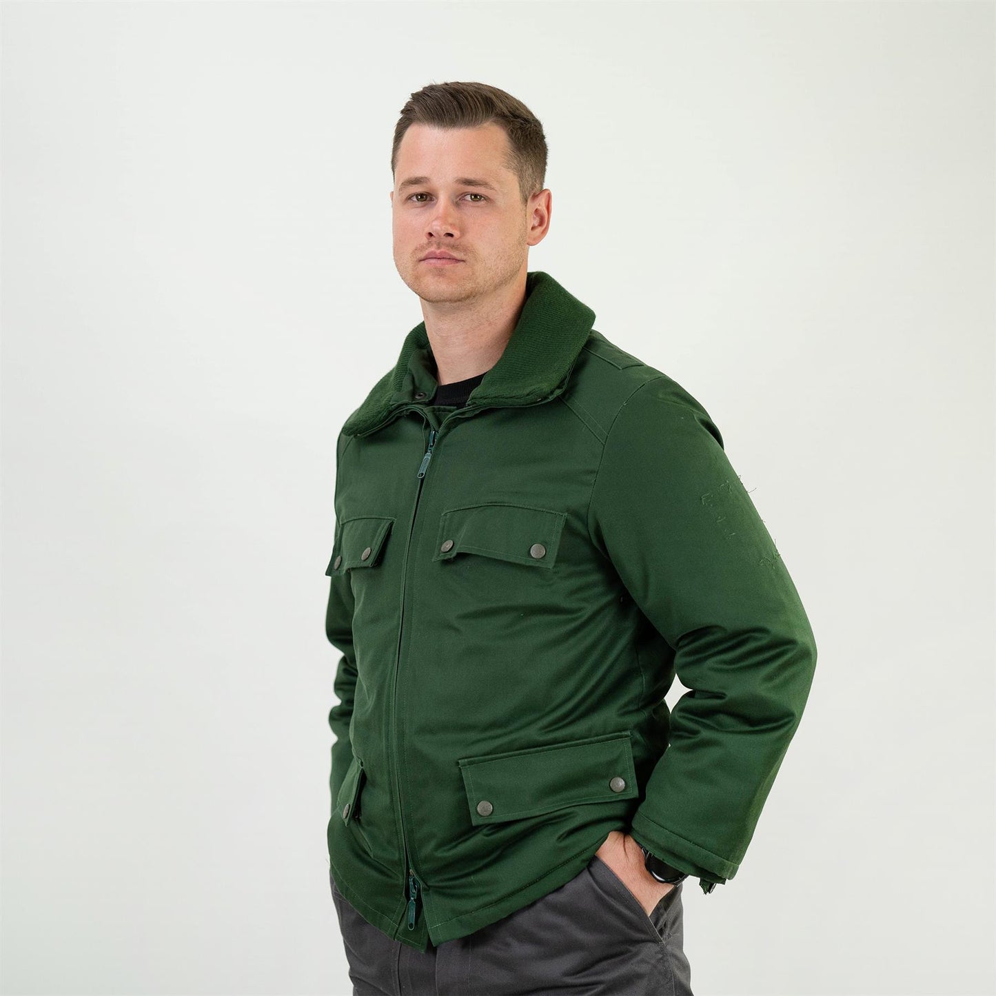 Vyras dėvi Vokietijos policijos pareigūnų parka stiliaus stirukę žalios spalvos šaltam orui.