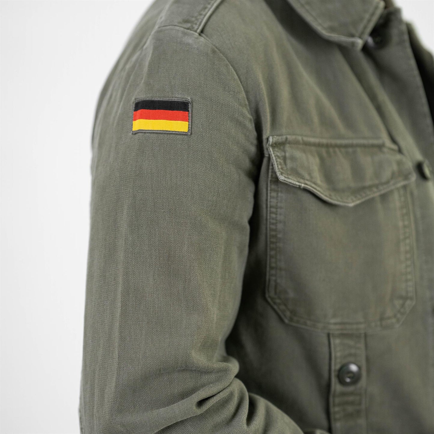 Vokietijos kariuomenės Bundesvero stiliaus švarkas pilkos spalvos su kišenėmis ir Vokietijos vėliavos emblema ant rankovės.